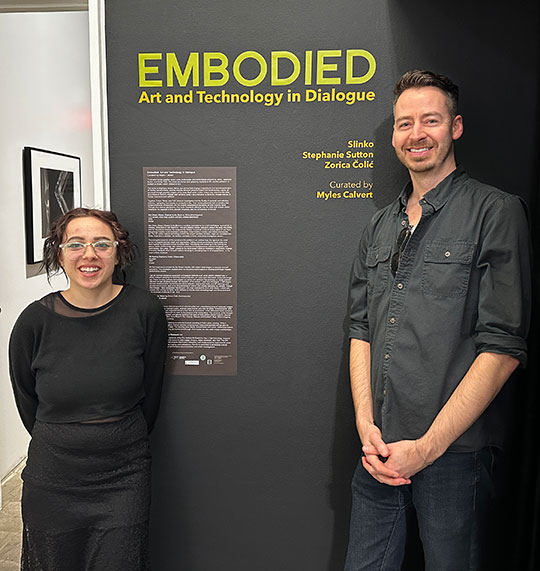 woman and man standing in front of a sign