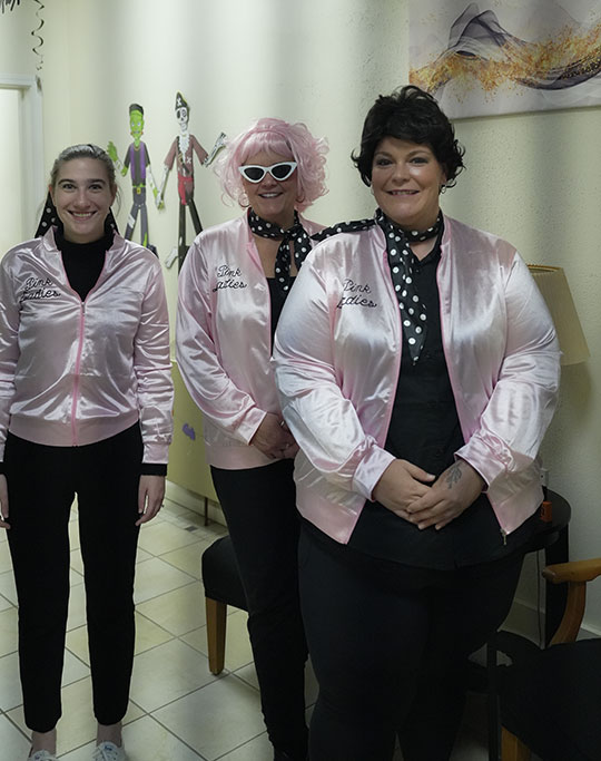 three women dressed in shiny pink jackets