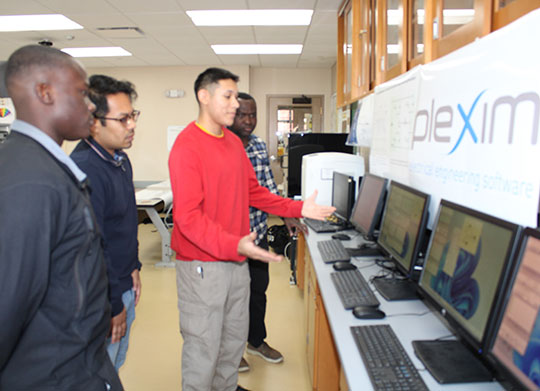 four people looking at computer screens