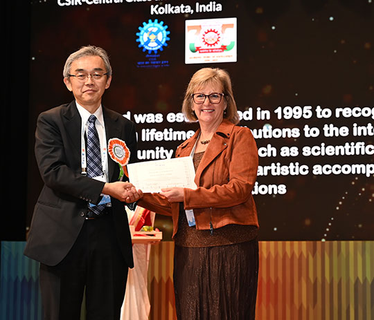 woman with glasses getting certificate from man in suit and tie