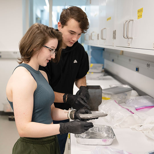 two people looking over a ceramic tile
