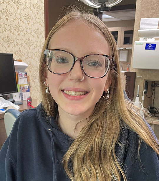 Headshot of young woman with blonde hair and glasses