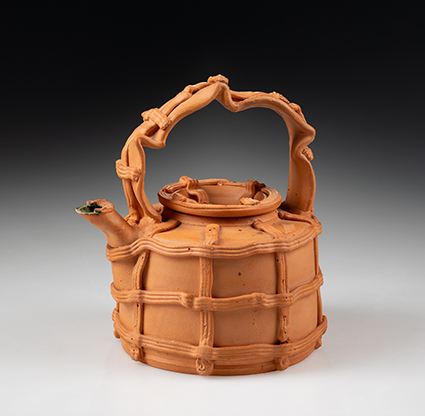 Terracotta teapot with a unique, lattice-like design. The intricate handle and spout highlight craftsmanship. The tone is earthy and artistic.