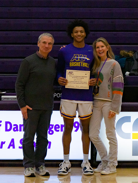three people, one holding a certificate
