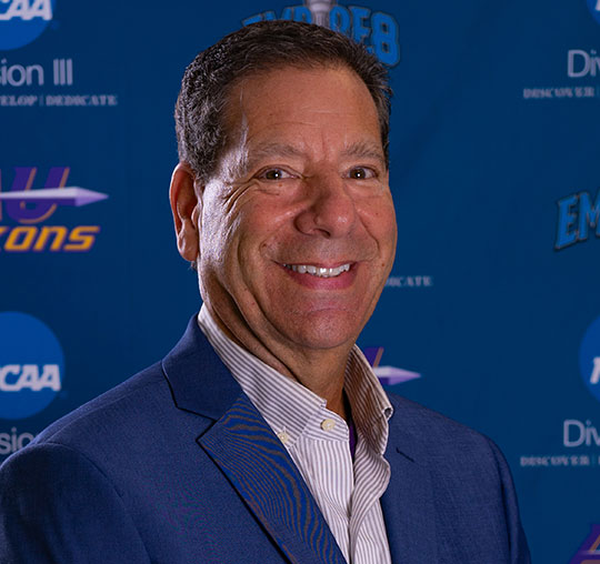 headshot of man in a sport coat smiling
