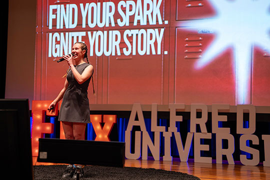 woman talking into a microphone on stage