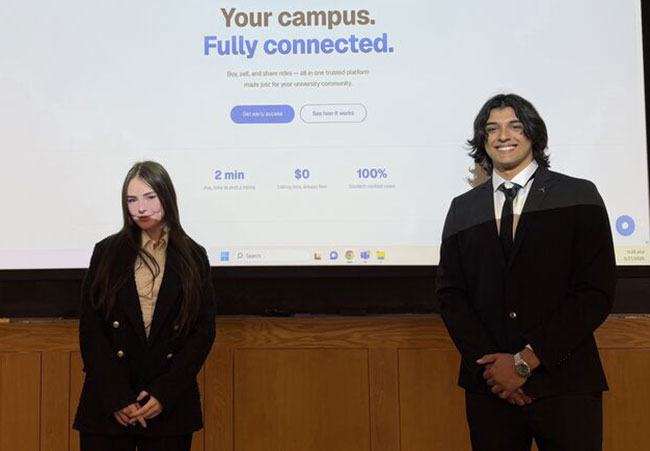 two young people standing in front of a projector screen
