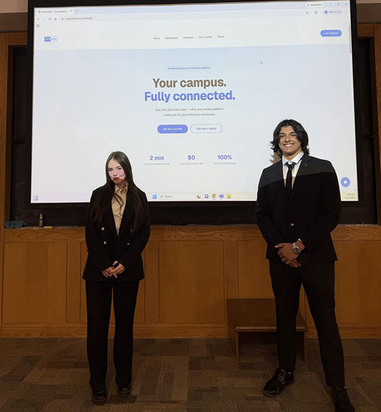 two people standing in front of a projector screen