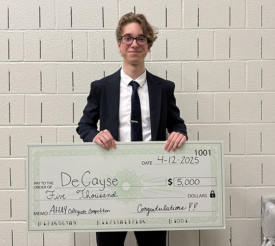 man wearing glasses holding a large check