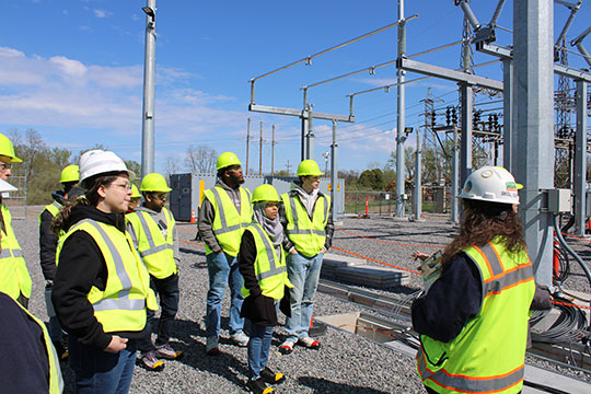 people standing and listening to someone talk to them