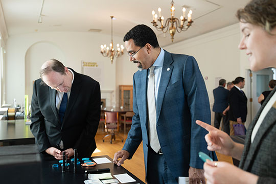 three people looking at items in a glass case