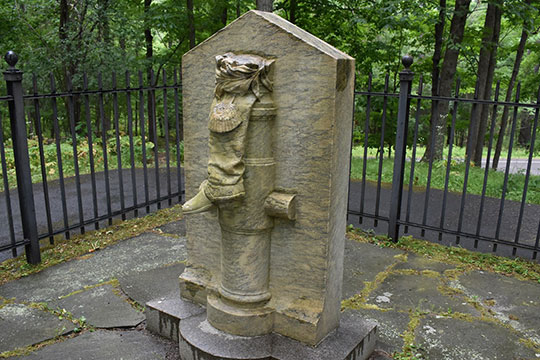 tombstone with image of a boot carved into it