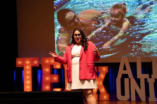 woman talking into a microphone on stage