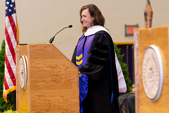 woman in cap and gown at a podium