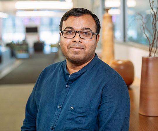 headshot of man wearing collared shirt and glasses
