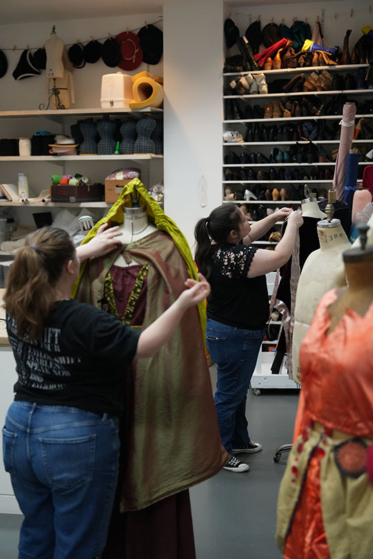 two young women working on costumes