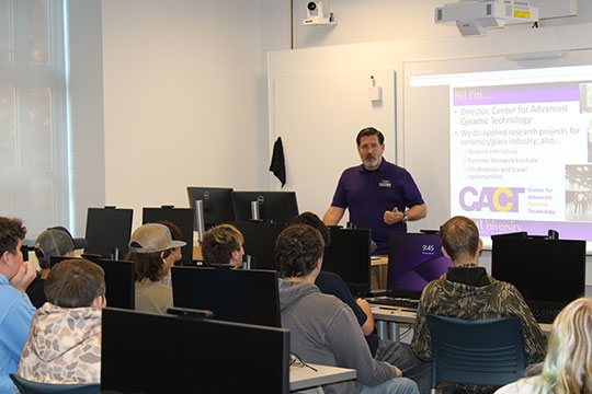 man standing in front of a classroom of students talking