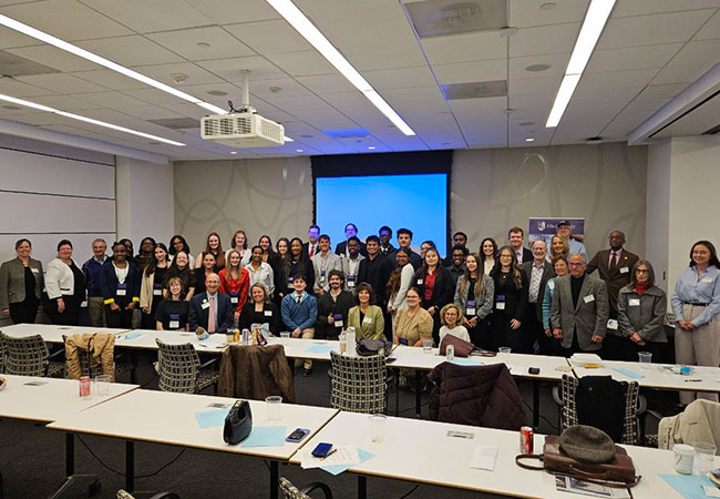 several people sitting and standing on a conference room