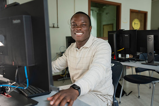 man sitting at a computer, smiling