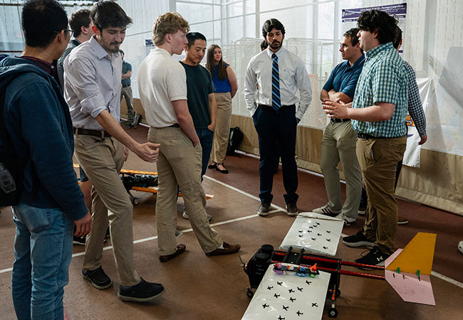 several people standing around a model airplane