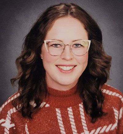 headshot of woman with long dark hair and glasses