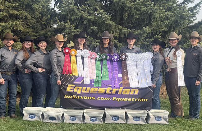 group of several people wearing cowboy hats, standing in a row in front of ribbons