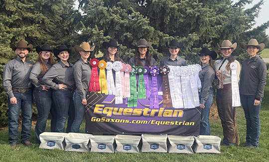 group of people wearing cowboy hats, standing in front of several ribbons