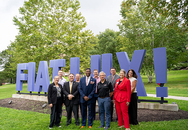 group of people in front of Fiat Lux sign