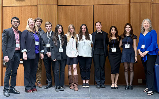 several people standing in a row, smiling