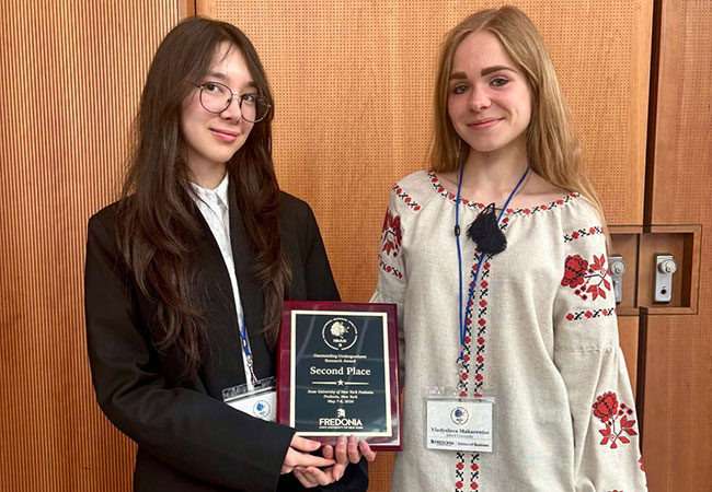 two women holding a plaque
