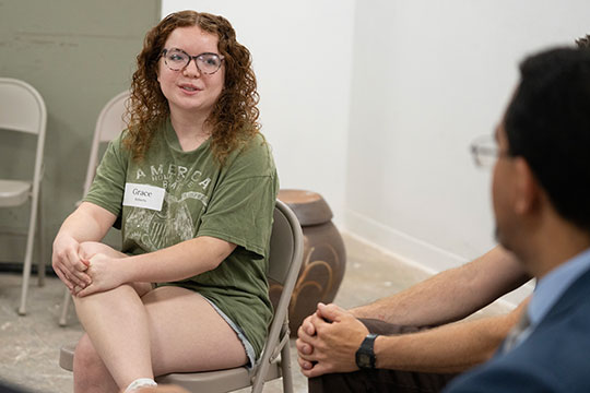 woman sitting in a chair talking to a man