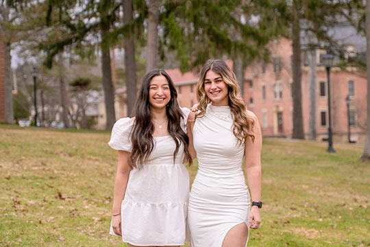 two women standing next to each other, smiling