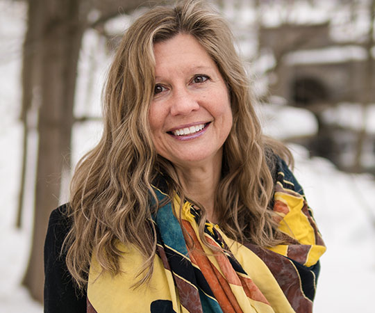 headshot of woman wearing scarf, smiling