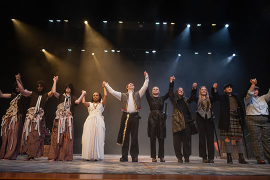 group of actors on stage taking a bow