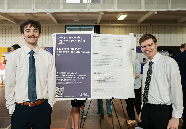two young men standing in front of a poster