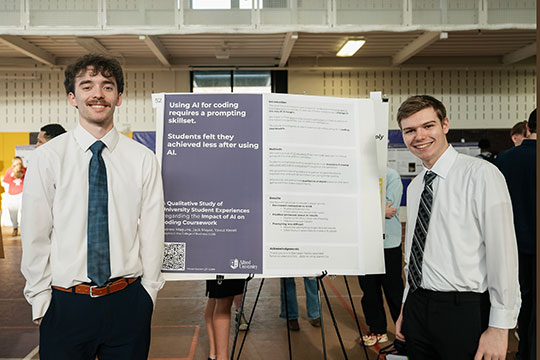 two young men sdtanding in front of a poster