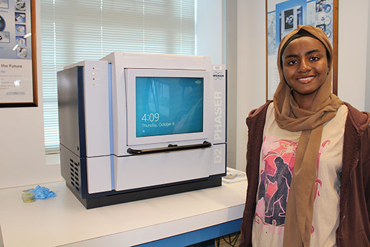 woman standing next to a piece of equipment