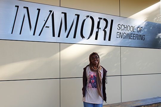 woman standing in front of a sign outside a building
