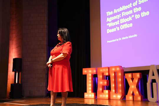 woman talking into a microphone on stage