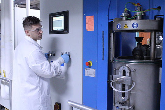 man in lab coat operating equipment