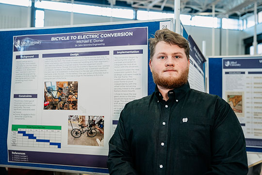 man standing in front of a poster