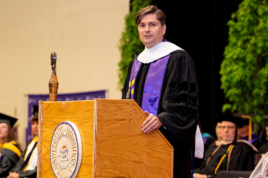 man in gown at podium