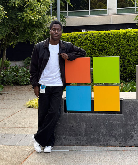 man standing by a sign in front of a building