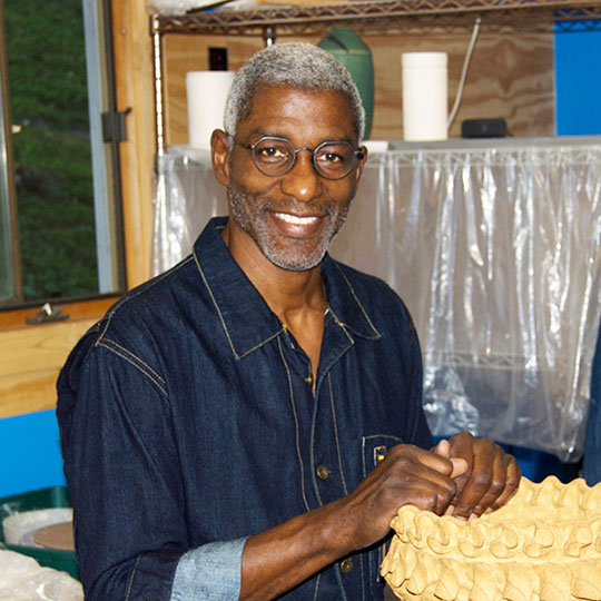 headshot of a man holding some pottery