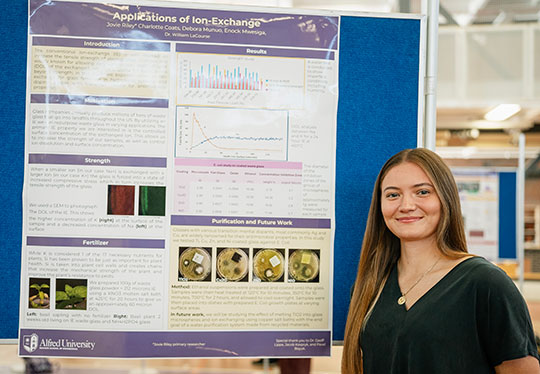 young woman standing in front of a poster