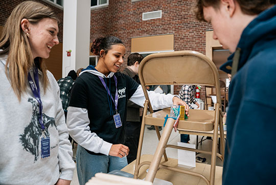 three people at a table working on a group project