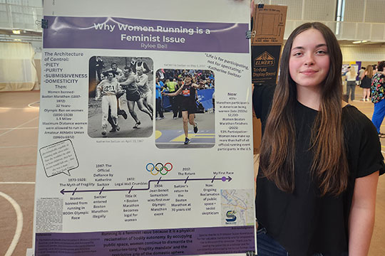 woman standing in front of a poster