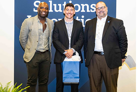 three men standing in a row smiling
