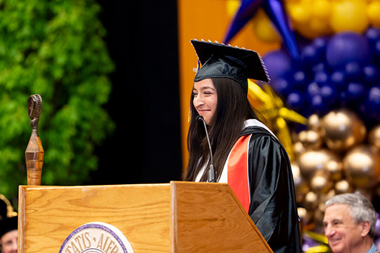 woman in cap and gown at a podium