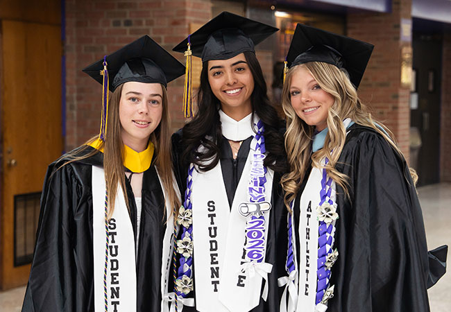 three young women in caps and gowns